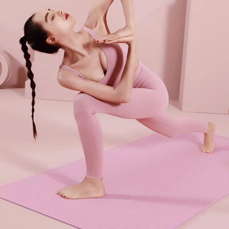 Woman stretching in a lunge on a pink foldable mat